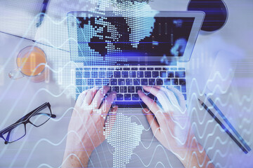 Double exposure of man's hands typing over laptop keyboard and forex chart hologram drawing. Top view. Financial markets concept.