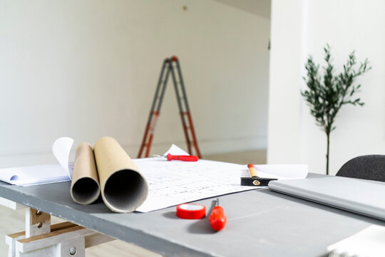 Rolled up blueprints lying on desk in architect studio