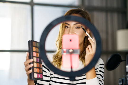 Woman teaching make-up on video call while sitting at home