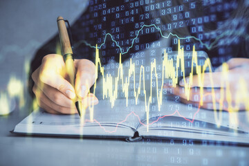 Double exposure of businesswoman hands typing on computer and forex graph hologram drawing....