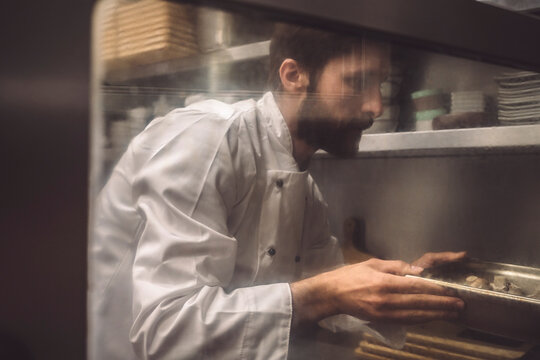 Male chef baking mushroom in commercial kitchen