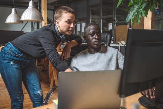 Computer programmers working on computer at workplace