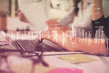 Multi exposure of woman hands typing on computer and financial graph hologram drawing. Stock market analysis concept.