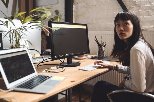Businesswoman looking away while working on computer at workplace