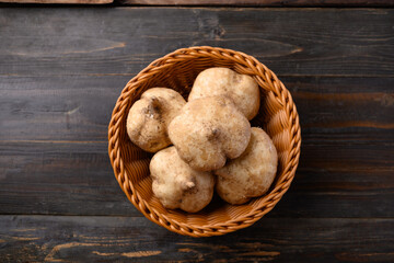 Fresh jicama or yam bean in a basket on wooden background, Jicama can be eaten raw or cooked, The taste are crisp, juicy, moist, and slightly sweet