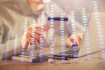 Double exposure of man hands holding a credit card and Forex graph drawing. Stock trading and digital fintech in Internet E-commerce concept.