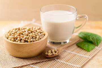 Soy beans in a bowl and soy milk in glass on wooden background