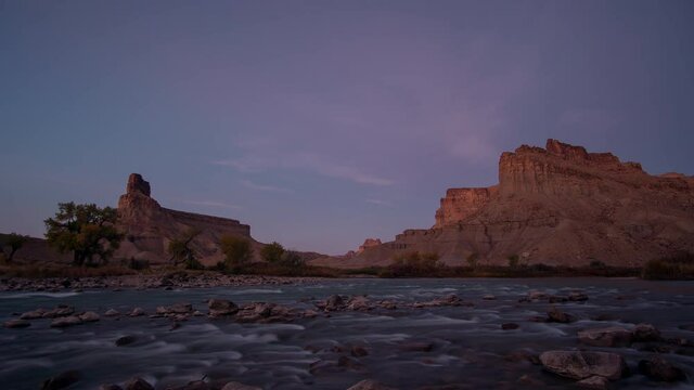Sunrise time lapse over the Green River in the Utah desert from Swaseys Beach as the cliffs light up.