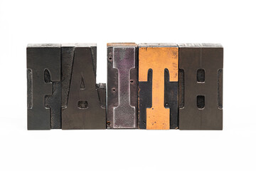 Wooden letterpress letters spelling the word FAITH isolated on a white background