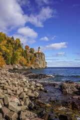 Split Rock Lighthouse on clear blue sky with puffy white clouds