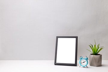 blank frame mockup on a white desk. gray wall background. office or home workplace. work planning concept. greeting card template