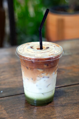 Cup of healthy drink mixed with green tea and milk in layers of color.