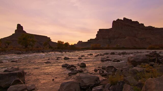 Panning over the Green River during sunset in Utah moving in slow motion across the pink landscape.