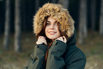 Pretty woman in an autumn jacket on the background of the forest smile travel
