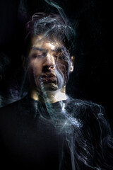 Portrait of a young male with beams of light and color projecting from his face and body...