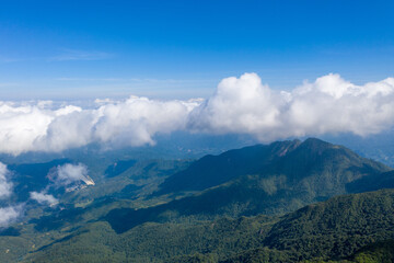 Naklejka na ściany i meble Aerial photography of blue sky and white clouds on the mountain