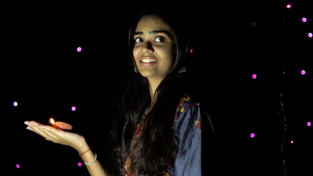 Indian girl with diwali diya(oil lamp). Girl holding diva with bokeh background. Diwali is biggest festival of India. Diwali is festival of lights and happiness.