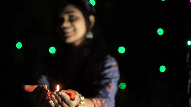Indian girl with diwali diya(oil lamp). Girl holding diva with bokeh background. Diwali is biggest festival of India. Diwali is festival of lights and happiness.