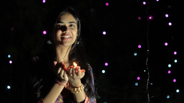 Indian girl with diwali diya(oil lamp). Girl holding diva with bokeh background. Diwali is biggest festival of India. Diwali is festival of lights and happiness.