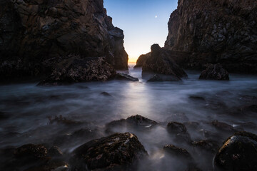 Fototapeta na wymiar Long exposure image of the rocks in the famous Pfeiffer Beach as the moon sets.