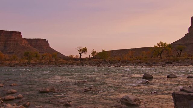 Panning up the Green River during sunset in Utah as the light glows in the desert.