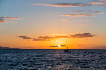 Naklejka na ściany i meble Silhouette of a boat in the Maui coast right before sunset. Hawaii, USA.