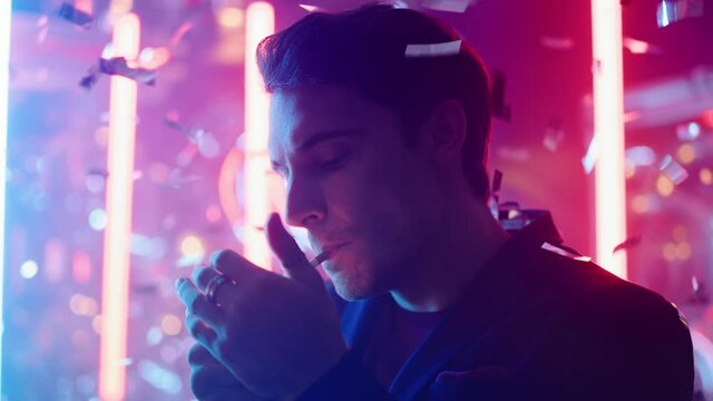 Thoughtful guy smoking in nightclub. Serious man lighting cigarette at party