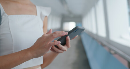 Woman use of mobile phone in pedestrian walkway