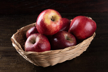 Red apples in basket with wooden background