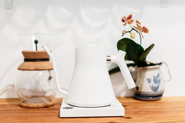 Hot water kettle, coffee maker, and orchid on kitchen counter