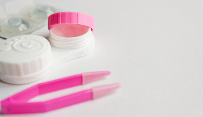 Contact lens, case and tweezers on gray background. Selective focus. Close up