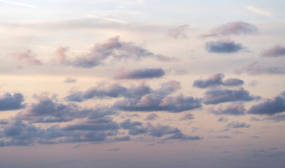 Cloudy sky at sunset or sunrise. Sky in the lilac and blue colors. Light pastel colored sunset clouds