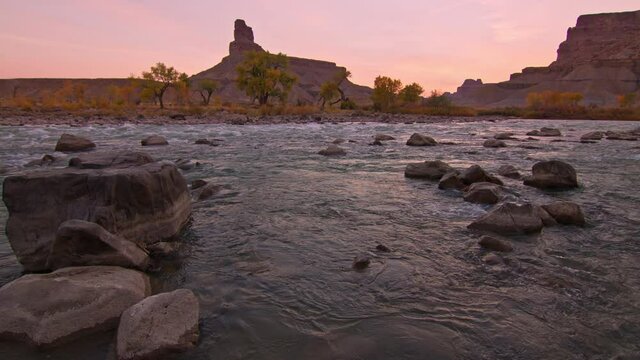 The Green River flowing through the desert in Utah with colorful sky during Fall.