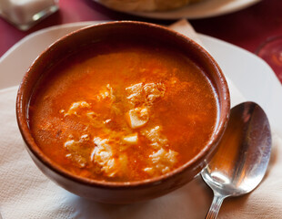 Clay bowl of Castilian garlic soup rich with bread, stringy egg and punchy broth. Spanish cuisine..