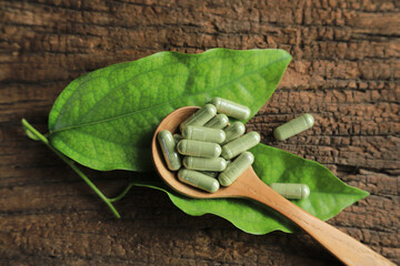 Herbal capsules from herbs leaf herb on spoon for health care eating in daily life. organic...