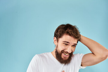 Emotional man with a beard in a white t-shirt blue background fun lifestyle