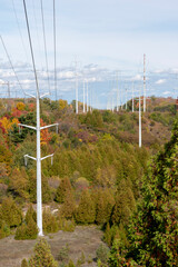 A group of electrical power lines crosses the Rouge River Valley in an urban park in Toronto (Scarborough), Ontario in the midst of the Autumn foliage.