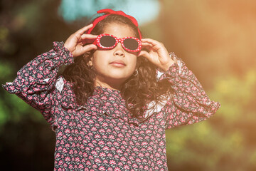 Latin young girl with sunglasses in a park