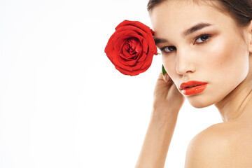 Beautiful woman with red rose near face makeup naked shoulders portrait