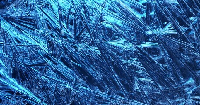 Frost covered window with lights shimmering and glittering over ice crystals.