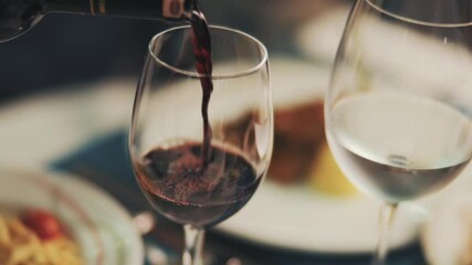 Red wine poured into a wine glass in a restaurant. - Powered by Adobe