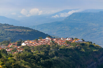 Fototapeta na wymiar Aerial view of the historic town Barichara high on a cliff in sunlight, mountains in background, Colombia 