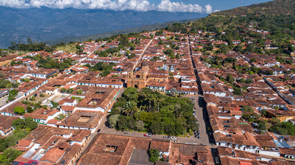 Aerial view panorama of historic town Barichara, Colombia situated on a cliff edge with white cloud...
