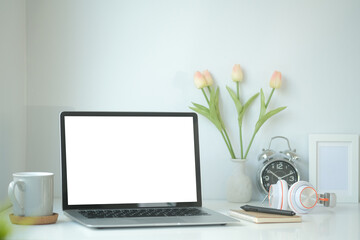 Fototapeta premium Front view of minimal desk with white blank screen laptop monitor for product display montage.