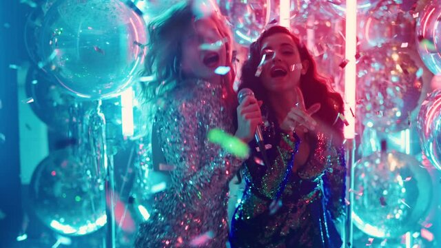 Cheerful women singing song in nightclub. Sexy girls performing song in karaoke