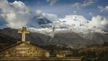 cross in front of the Huascar&aacute;n mountain in Yungay