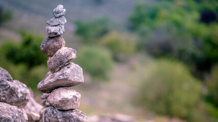 Balanced Zen stones on green nature background.