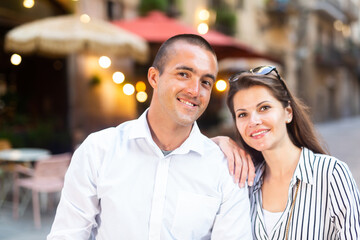 Portrait of elegant romantic couple of tourists walking around summer city streets