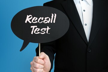 Recall Test. Businessman holds speech bubble in his hand. Handwritten Word/Text on sign.