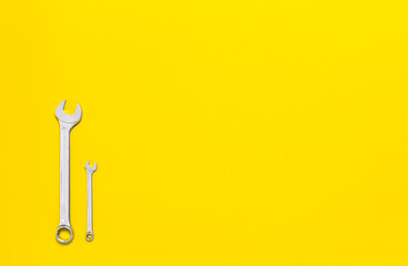 Three metal wrenches of different sizes isolated on a red background with copy space. Conceptual idea of the differences between: boss and employee, older and younger, big and small, parent and child